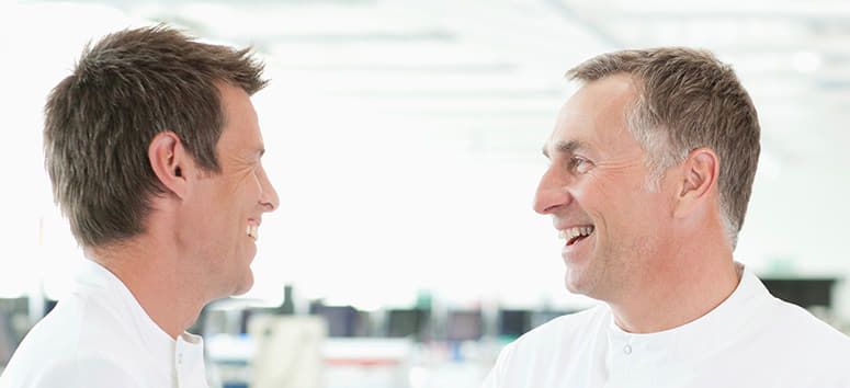Zwei Männer gucken sich an und lachen